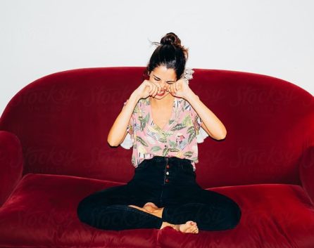 Girl Laughing on Red Couch